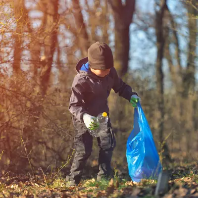Child picking up litter in forest
