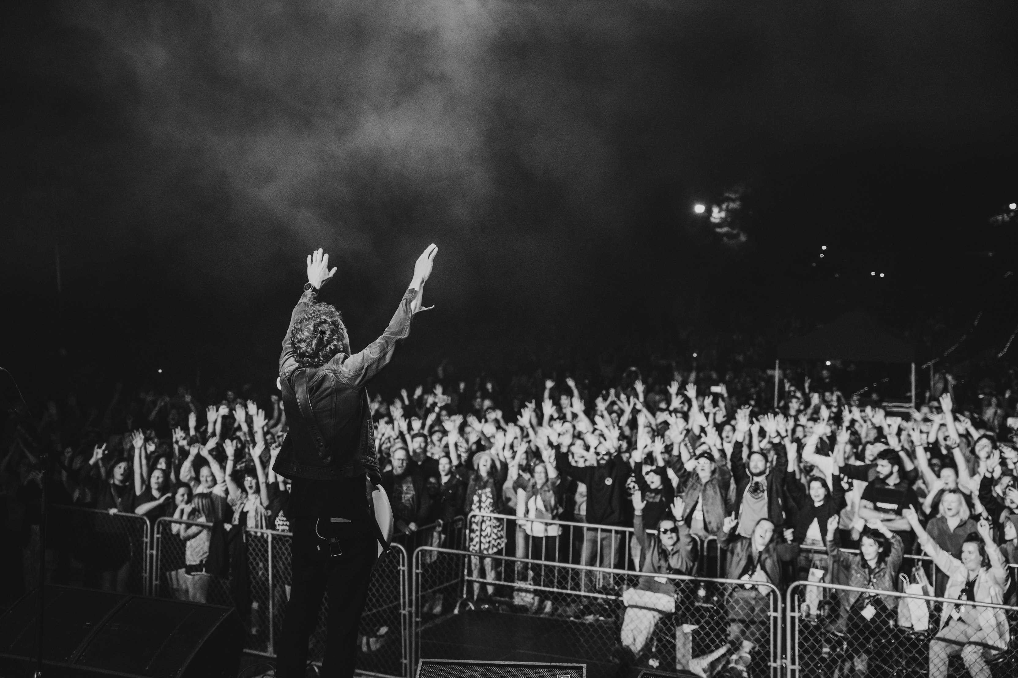 musician on stage waving to a large crowd
