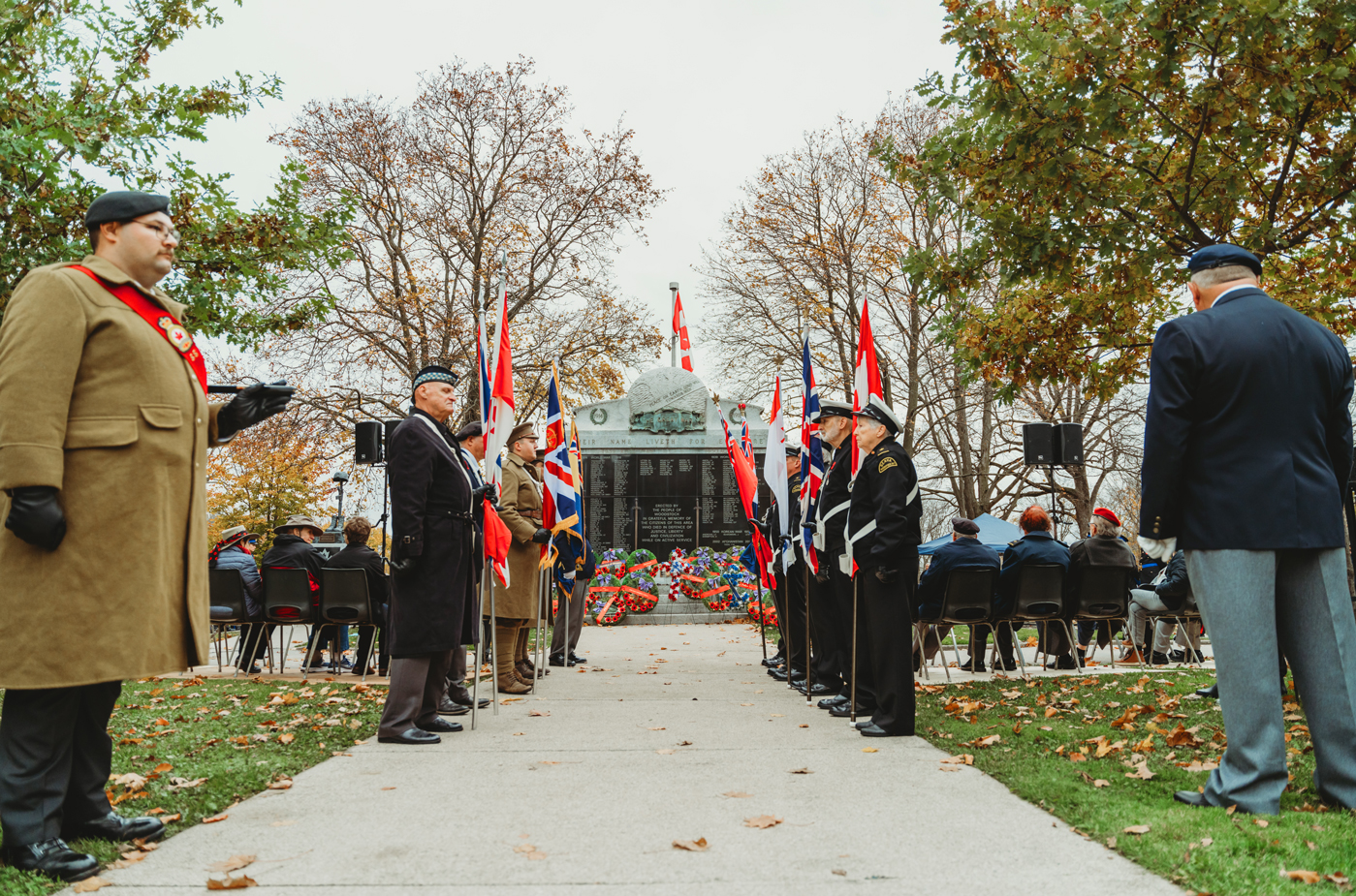 people in a line in front of the City of Woodstock Cenotaph